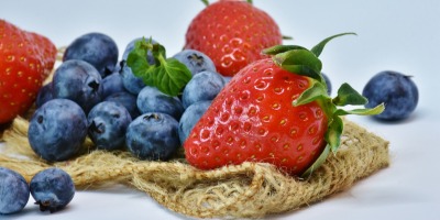 strawberries and blueberries sitting on burlap